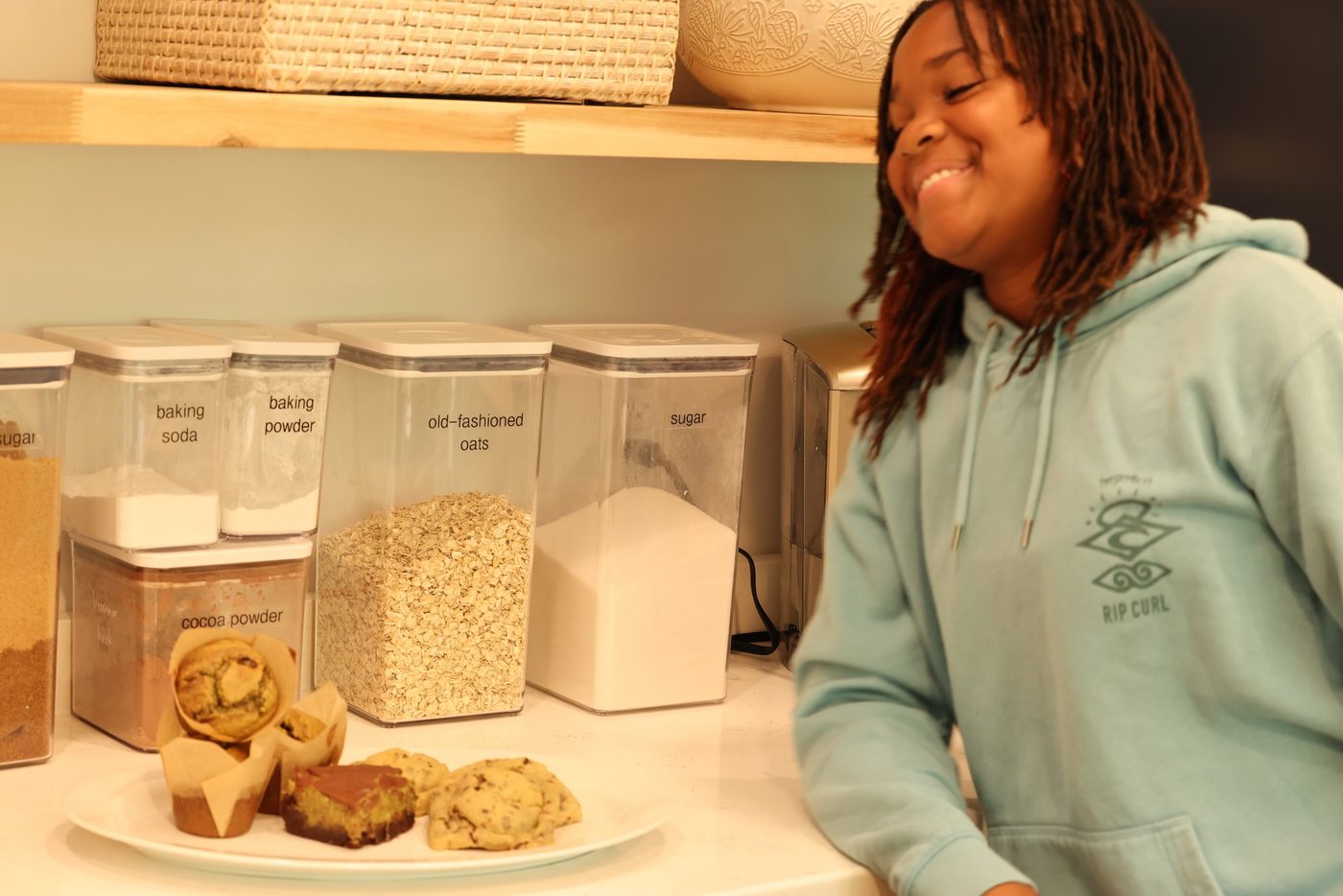 Kaleigh smiling as she plates a fresh batch of cookies